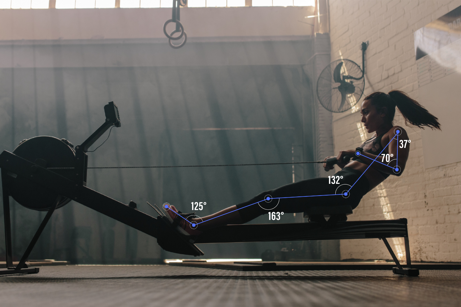 An athlete using a rowing machine. MediaPipe landmarks are overlaid on her joints and range of motion angles are highlighted for ankle, knee, hip and elbow.